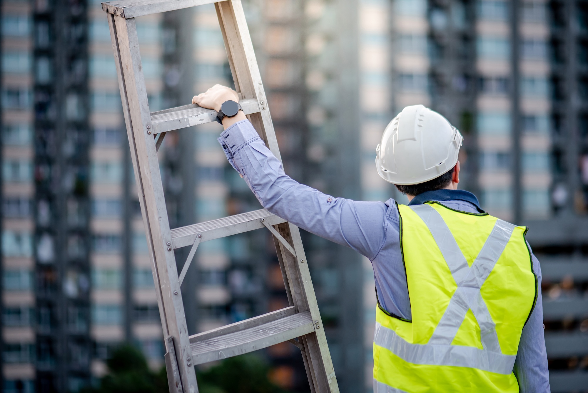 Man in safety vest with a ladder